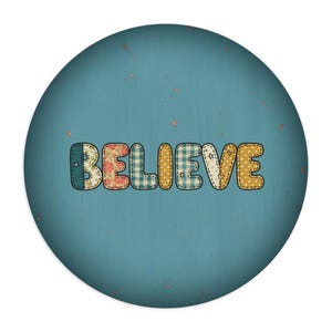 May include: Round teal-colored decorative item with the word "BELIEVE" in patchwork-style letters. The letters are in various patterns, including floral, gingham, and polka dots, with a stitched border.