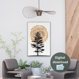 May include: A digital download of a printable art print featuring a silhouette of a pine tree in front of a full moon. The moon is a watercolour style with a gold and brown colour scheme. The text "Rooted in the stillness guided by the moon" is written in black above the moon.