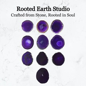 May include: Ten purple agate coasters with a variety of patterns. The coasters are round and have a polished finish. The text "Rooted Earth Studio" and "Crafted from Stone, Rooted in Soul" is visible at the top of the image.