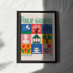 Op de afbeelding: Een ingelijste poster met een kleurrijk, geometrisch ontwerp met illustraties van een eend, boom, poort, buste, prieel, bloemen en tulpen. De tekst "THE PUBLIC GARDENS HALIFAX NS" wordt weergegeven in groen en wit.