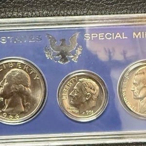 May include: A 1966 United States Special Mint Set in a clear plastic case. The set includes a Kennedy half dollar, a quarter, a dime, a nickel, and a penny. The coins are displayed on a blue background.