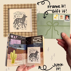 May include: A framed print featuring a black and white illustration of a coyote with a desert landscape. A green envelope with stamps and a bow is held by a hand. A journal with a cactus and the word "MAY" is open.