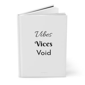 May include: A white hardcover book standing upright and slightly open at the top. The front cover features the black text Vibes, Vices, and Void stacked vertically in the center. The book has a clean, solid white finish with visible page edges.