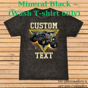 May include: Black mineral wash t-shirt with a custom design. It features a monster truck graphic within a yellow triangle, with the words "CUSTOM" and "TEXT". The shirt is a wash t-shirt.