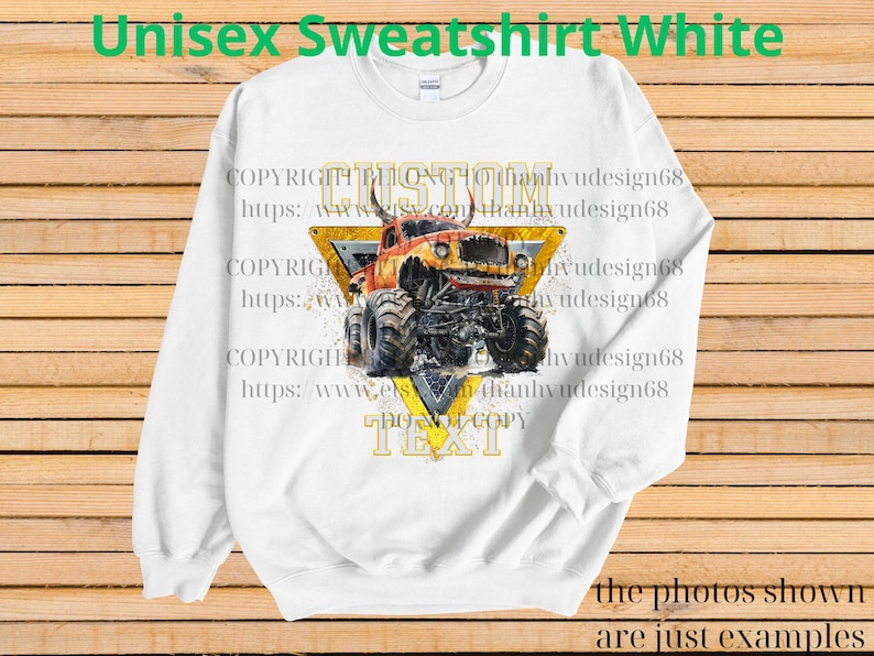 May include: White unisex sweatshirt with a graphic of a monster truck in orange, yellow, and black. The design includes the words "CUSTOM" and "TEXT" within a yellow triangle. The text "Unisex Sweatshirt White" is at the top.