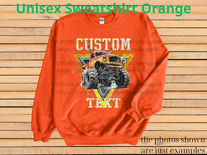 May include: Orange unisex sweatshirt featuring a monster truck graphic. The design includes the word "CUSTOM" above the truck and "TEXT" below, set against a yellow and black triangle. The sweatshirt has long sleeves and a crew neck.