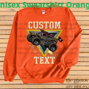 May include: Orange unisex sweatshirt featuring a custom design with a monster truck graphic. The design includes the word "CUSTOM" above the truck and "TEXT" below. The sweatshirt has a crew neck and long sleeves.