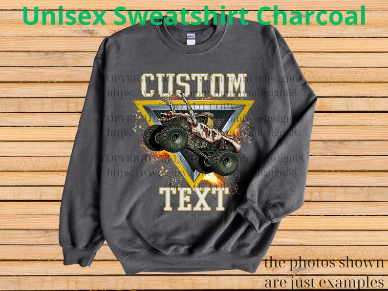 May include: Charcoal grey unisex sweatshirt with a monster truck graphic. The design includes the words "CUSTOM" and "TEXT" in a bold font, and a monster truck graphic inside a yellow triangle. The text "Unisex Sweatshirt Charcoal" is at the top.