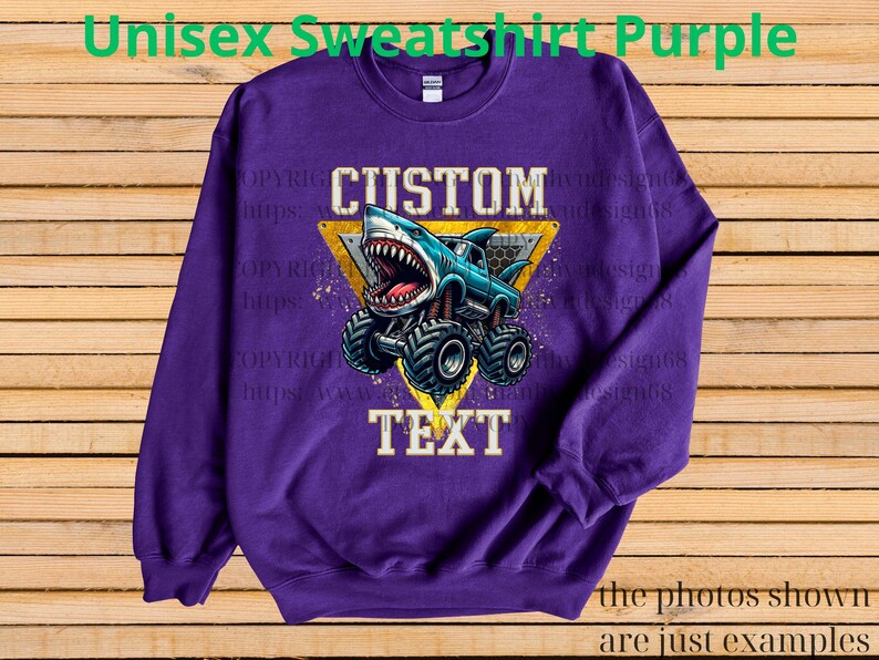 May include: Purple unisex sweatshirt featuring a shark-themed monster truck design. The graphic includes the words "CUSTOM TEXT" within a yellow triangle. The text "Unisex Sweatshirt Purple" is at the top. The bottom of the image says "the photos shown are just examples."
