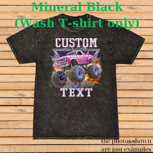 Op de afbeelding: Minerale zwarte was t-shirt met een roze monstertruck ontwerp. De afbeelding bevat de woorden "CUSTOM" en "TEXT". De monstertruck heeft grote blauwe en roze wielen en staat tegen een vurige achtergrond. De tekst "the photos shown are just examples" staat onderaan.