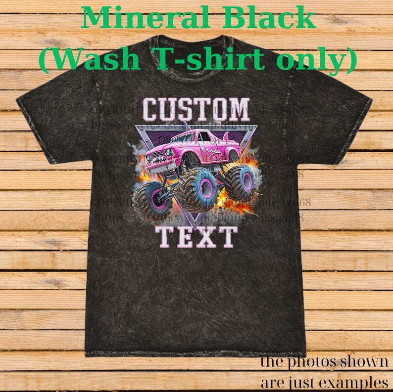 Op de afbeelding: Minerale zwarte was t-shirt met een roze monstertruck ontwerp. De afbeelding bevat de woorden "CUSTOM" en "TEXT". De monstertruck heeft grote blauwe en roze wielen en staat tegen een vurige achtergrond. De tekst "the photos shown are just examples" staat onderaan.