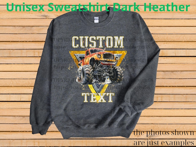 May include: Dark heather gray unisex sweatshirt featuring a custom design. The design includes a monster truck illustration within a yellow triangle, with the words "CUSTOM" and "TEXT" above and below the truck. The sweatshirt is a comfortable, casual style.