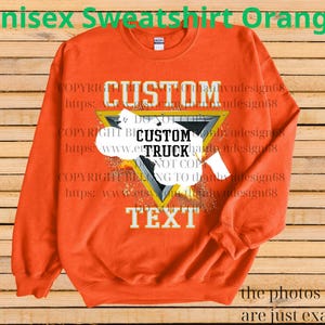May include: Orange unisex sweatshirt with a custom design. The design features the word "CUSTOM" above a triangle with the words "CUSTOM TRUCK TEXT" inside. The sweatshirt has long sleeves and a crew neck.