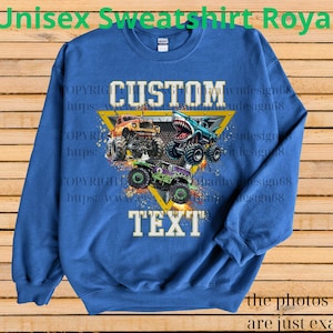 May include: Royal blue unisex sweatshirt with a graphic of three monster trucks in orange, teal, and purple. The sweatshirt has the words "CUSTOM TEXT" in white, and the text "Unisex Sweatshirt Royal" in green.