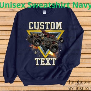 May include: Navy blue unisex sweatshirt with a custom design. The design features a monster truck graphic inside a yellow triangle, with the words "CUSTOM TEXT" in white. The text "Unisex Sweatshirt Navy" is at the top.