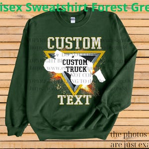 May include: Forest green unisex sweatshirt with a custom design. The design features the word "CUSTOM" above a yellow triangle with a white truck graphic and the word "TEXT" below. The text "Unisex Sweatshirt Forest Green" is at the top.