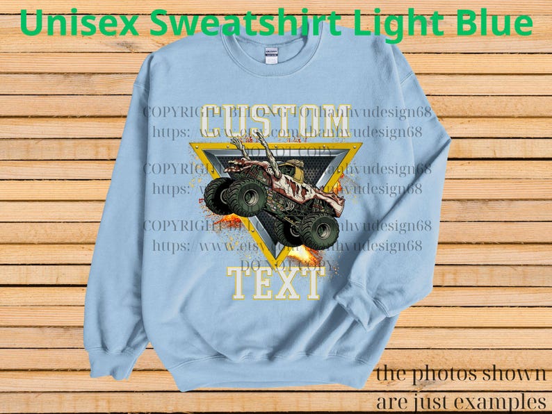 May include: Pale blue unisex sweatshirt featuring a monster truck graphic within a yellow triangle. The text "CUSTOM TEXT" is below the triangle. The words "Unisex Sweatshirt Light Blue" are at the top of the sweatshirt.