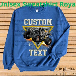 May include: Royal blue unisex sweatshirt with a custom design. The design features a monster truck graphic inside a yellow triangle, with the word "CUSTOM" above and "TEXT" below. The text "Unisex Sweatshirt Royal" is at the top.