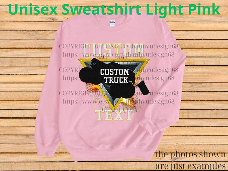 May include: Pale pink unisex sweatshirt featuring a black custom truck graphic within a yellow triangle. The words "CUSTOM TRUCK" are on the graphic. The sweatshirt also has the text "TEXT" at the bottom.