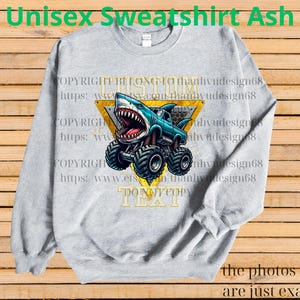 May include: Ash gray unisex sweatshirt featuring a cartoon shark monster truck design. The shark truck is blue with a yellow triangle background. The text "DO NOT COPY TEXT" is visible. The words "Unisex Sweatshirt Ash" are at the top.