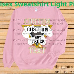 Może przedstawiać: Jasnor&oacute;żowa bluza unisex z napisem "CUSTOM ANY TRUCK TEXT" w tr&oacute;jkątnym wzorze. Bluza ma długie rękawy i okrągły dekolt. Słowa "Unisex Sweatshirt Light Pink" znajdują się u g&oacute;ry obrazu.