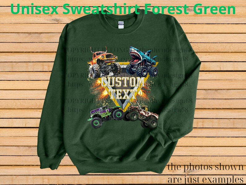 May include: Forest green unisex sweatshirt featuring a graphic of four monster trucks with the text "CUSTOM TEXT". The design includes a shark-themed truck and other trucks in orange, purple, and beige. The text "the photos shown are just examples" is also visible.