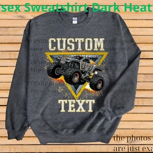 May include: Dark heather grey unisex sweatshirt with a custom design. The design features a monster truck inside a yellow triangle, with the words "CUSTOM" and "TEXT" in white. The sweatshirt has long sleeves and a crew neck.