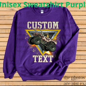 May include: A purple unisex sweatshirt with a custom design. The design features a monster truck inside a yellow triangle with the words "CUSTOM" and "TEXT". The text "Unisex Sweatshirt Purple" is at the top.