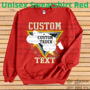 May include: Red unisex sweatshirt with a custom design. The design features the words "CUSTOM TRUCK TEXT" inside a yellow triangle. The sweatshirt also has the text "Unisex Sweatshirt Red" at the top.