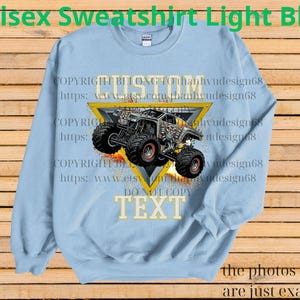 May include: Pale blue unisex sweatshirt with a monster truck design inside a yellow triangle. The words "CUSTOM" and "TEXT" are visible. The sweatshirt also has the text "Unisex Sweatshirt Light Blue".