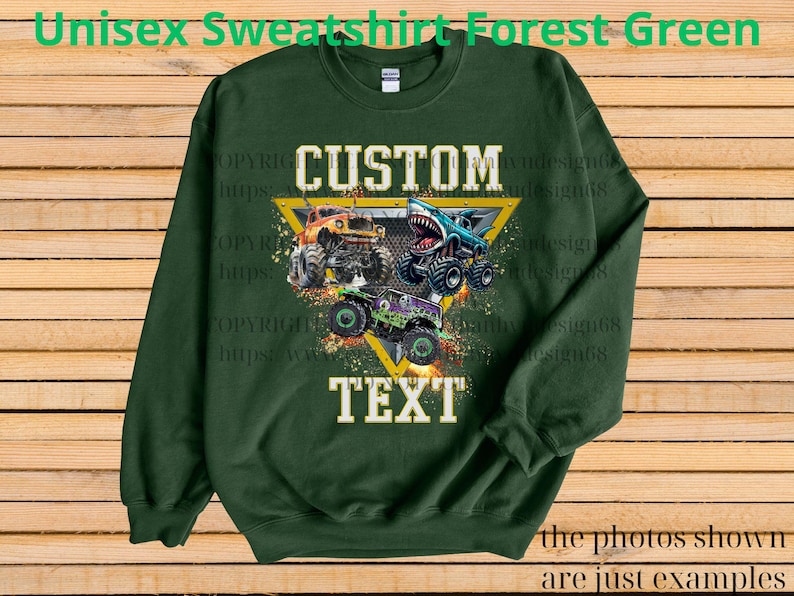 May include: Forest green unisex sweatshirt with a graphic of three monster trucks in orange, blue, and green. The design includes the words "CUSTOM" and "TEXT" in white, set within a yellow triangle. The text "Unisex Sweatshirt Forest Green" is at the top.