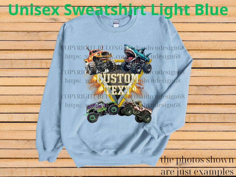 May include: Light blue unisex sweatshirt featuring a graphic of monster trucks with the text "CUSTOM TEXT". The sweatshirt has a crew neck and long sleeves. The words "Unisex Sweatshirt Light Blue" are at the top.