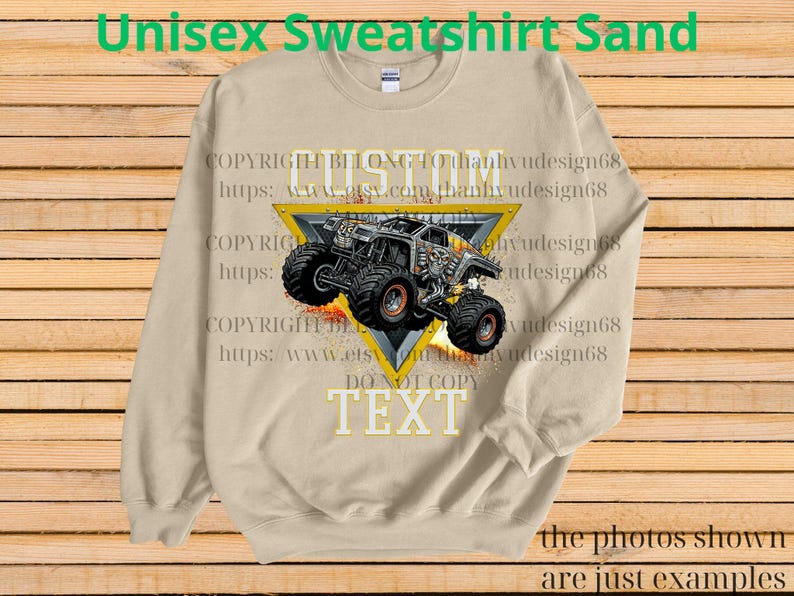 May include: A sand-coloured unisex sweatshirt with a monster truck design inside a yellow triangle. The text "CUSTOM" and "TEXT" are visible. The sweatshirt has long sleeves and a crew neck. The words "Unisex Sweatshirt Sand" are at the top.