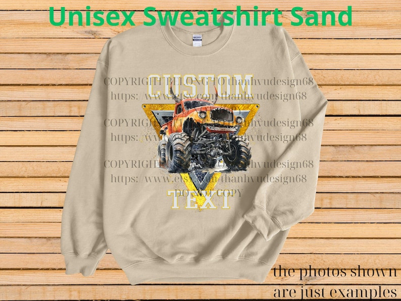 May include: Sand-colored unisex sweatshirt featuring a monster truck graphic within a yellow triangle. The text "CUSTOM" and "TEXT" are visible, along with the phrase "DO NOT COPY." The sweatshirt also has the text "Unisex Sweatshirt Sand."