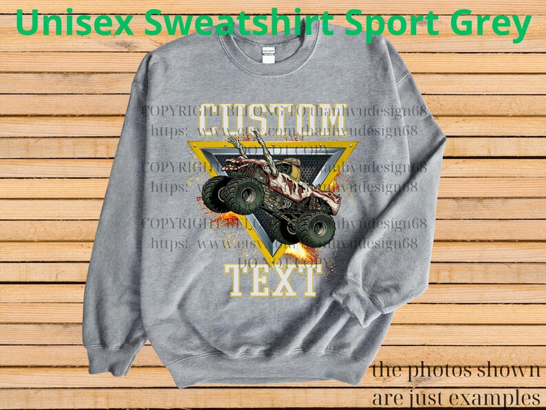May include: A grey unisex sweatshirt featuring a monster truck design within a yellow triangle. The words "CUSTOM" and "TEXT" are displayed above and below the truck graphic. The text "Unisex Sweatshirt Sport Grey" is at the top.