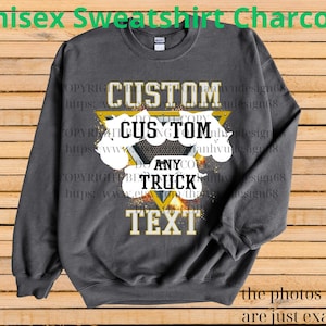 Może przedstawiać: Szara bluza unisex z nadrukiem. Projekt zawiera słowo "CUSTOM" nad "ANY" i "TRUCK" oraz "TEXT" w kolorze złotym i białym. Bluza jest prezentowana na drewnianym tle.