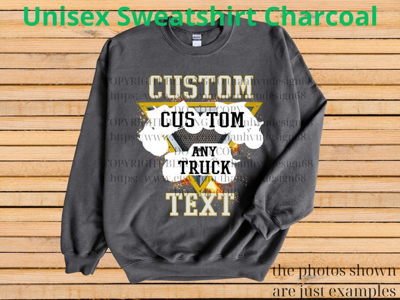 Może przedstawiać: Szara bluza unisex z nadrukiem. Projekt zawiera słowo "CUSTOM" nad "ANY" i "TRUCK" oraz "TEXT" w kolorze złotym i białym. Bluza jest prezentowana na drewnianym tle.