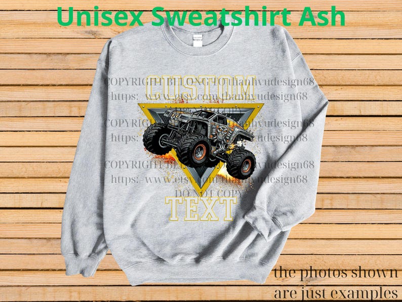 May include: Ash grey unisex sweatshirt with a monster truck design inside a yellow triangle. The design includes the text "CUSTOM TEXT" and "DO NOT COPY TEXT". The sweatshirt has long sleeves and a crew neck.
