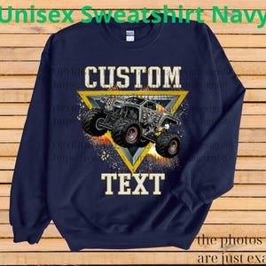 May include: Navy blue unisex sweatshirt with a custom design. The design features a monster truck inside a yellow triangle, with the words "CUSTOM" and "TEXT" in white. The text "Unisex Sweatshirt Navy" is at the top.