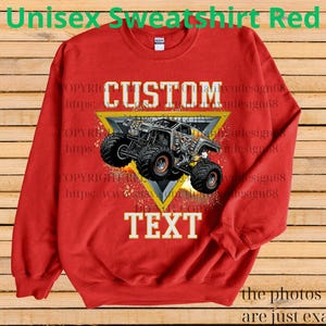 May include: A red unisex sweatshirt featuring a monster truck design within a yellow triangle. The words "CUSTOM" and "TEXT" are prominently displayed. The top of the sweatshirt reads "Unisex Sweatshirt Red".