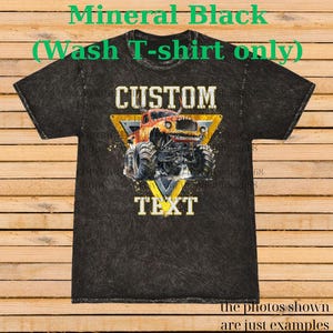 May include: Black mineral wash t-shirt with a custom monster truck design. The design features a yellow triangle with the words "CUSTOM" and "TEXT". The monster truck is red and yellow. The text "Mineral Black (Wash T-shirt only)" is at the top.