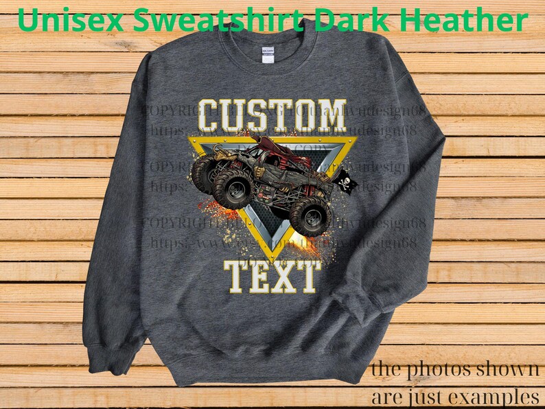May include: Dark heather gray unisex sweatshirt with a custom design. The design features a monster truck graphic inside a yellow triangle, with the words "CUSTOM TEXT". The sweatshirt is a comfortable, casual style.