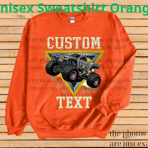 May include: Orange unisex sweatshirt with a custom monster truck design. The graphic is inside a yellow triangle, with "CUSTOM" above and "TEXT" below. The sweatshirt has a crew neck and long sleeves.