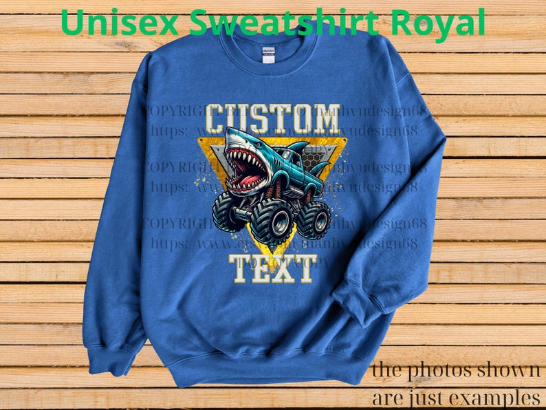 May include: Royal blue unisex sweatshirt featuring a monster truck with a shark design. The truck is blue with a shark head and large tires. The words "CUSTOM" and "TEXT" are displayed. The text "Unisex Sweatshirt Royal" is at the top.
