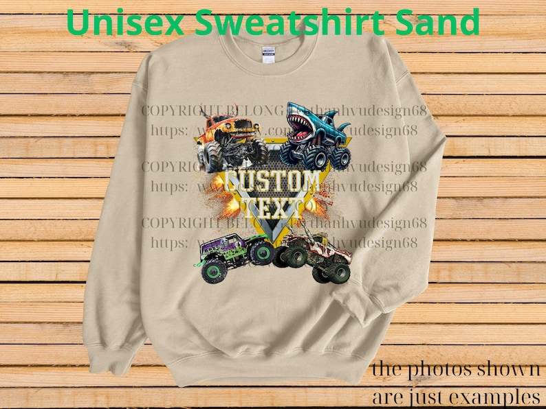 May include: Sand-colored unisex sweatshirt featuring a graphic of monster trucks, including a shark-themed truck. The design includes the text "CUSTOM TEXT" and "Unisex Sweatshirt Sand". The photos shown are just examples.