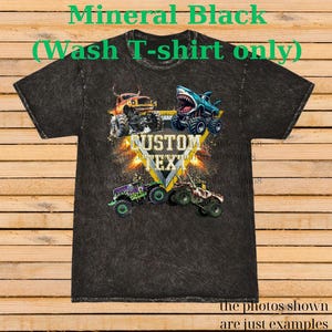 May include: Mineral black wash t-shirt featuring a graphic of monster trucks with the text "CUSTOM TEXT". The shirt has a distressed look and the text "Mineral Black (Wash T-shirt only)" is printed at the top. The bottom of the shirt has the text "the photos shown are just examples".