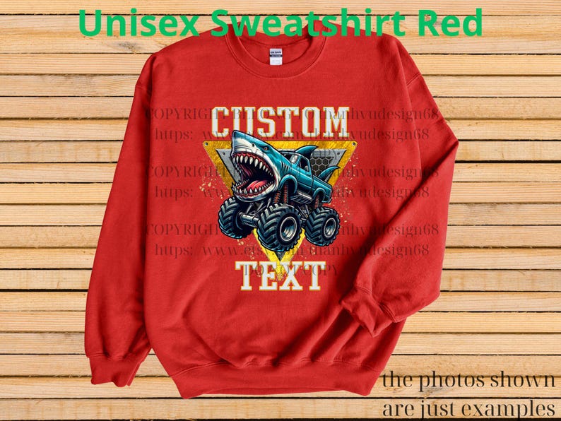 May include: Red unisex sweatshirt featuring a shark-themed monster truck design. The graphic includes the words "CUSTOM TEXT" in white, set against a yellow triangle. The sweatshirt has long sleeves and a crew neck.