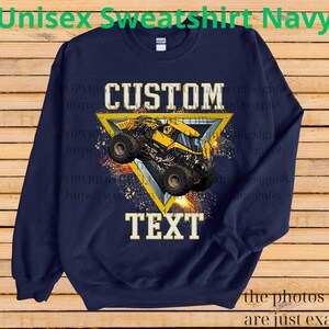 K&ouml;nnte beinhalten: Marineblaues Unisex-Sweatshirt mit individuellem Design. Das Design zeigt einen gelb-schwarzen Monstertruck in einem gelben Dreieck mit den wei&szlig;en W&ouml;rtern "CUSTOM" und "TEXT". Der Text "Unisex Sweatshirt Navy" steht oben.