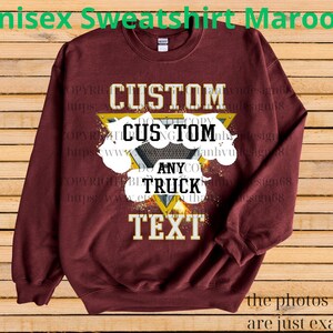 Może przedstawiać: Bordowa bluza unisex z okrągłym dekoltem. Z przodu znajduje się niestandardowy wz&oacute;r ze słowami "CUSTOM", "ANY", "TRUCK" i "TEXT" w białych i złotych literach, na tle geometrycznego kształtu i chmur.