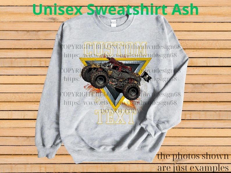 May include: Ash gray unisex sweatshirt featuring a monster truck design within a yellow triangle. The truck is red and black with large tires. The text "CUSTOM TEXT" is below the truck. The words "Unisex Sweatshirt Ash" are at the top.